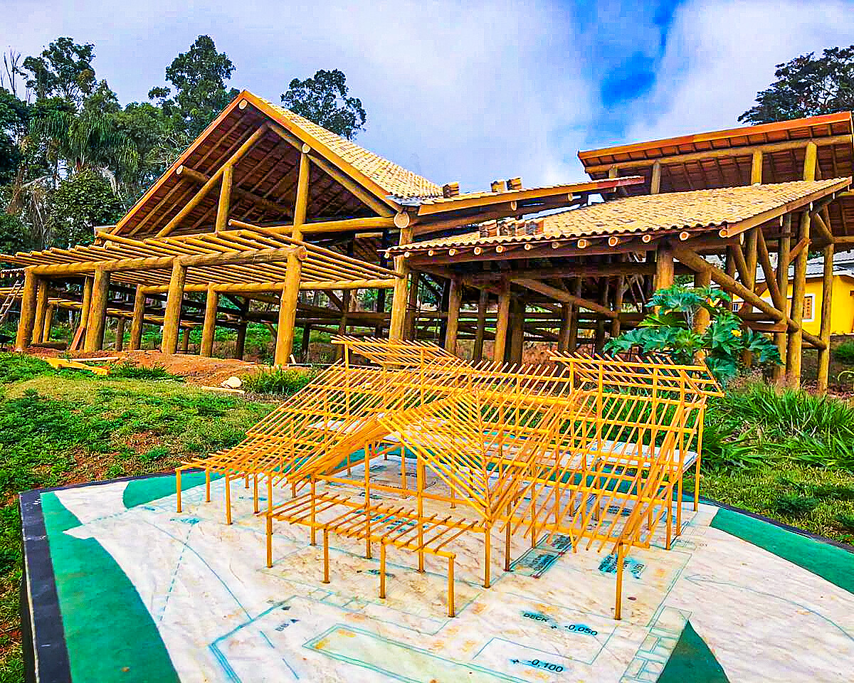 Maquete física de estrutura em madeira ao lado da obra executada