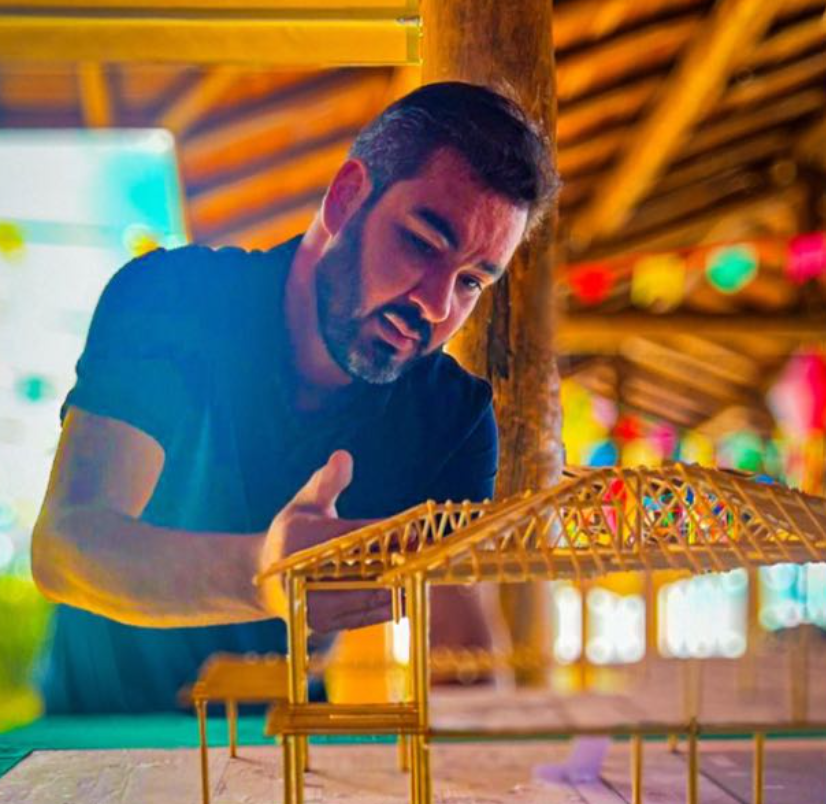 Danilo Diniz, engenheiro civil e CEO da Construtora Diniz Florentino, analisando uma maquete estrutural em madeira